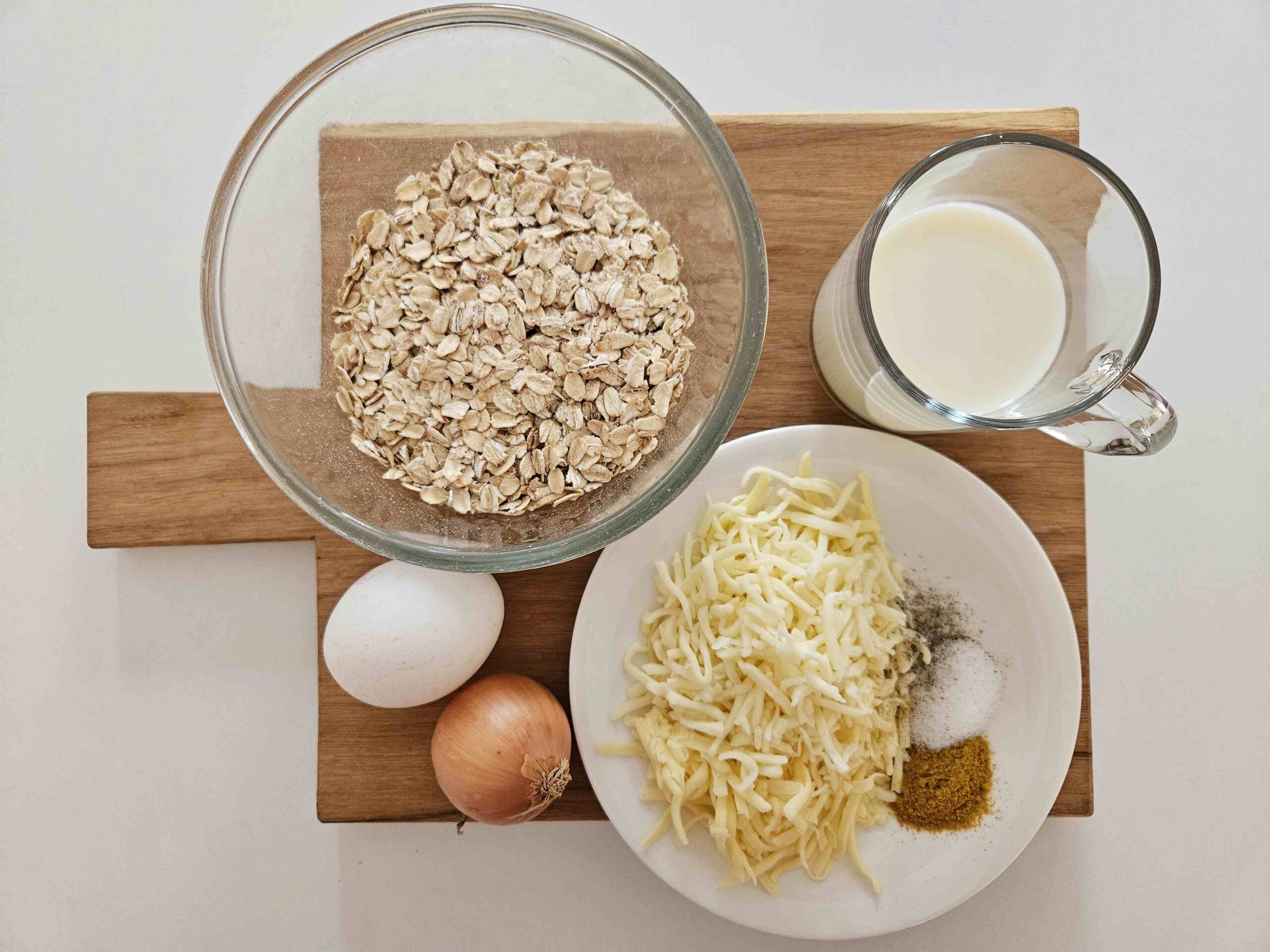 Zutaten für die Haferflocken-Käse-Frikadellen: Haferflocken, Milch, Käse, Gewürze, ein Ei, eine Zwiebel