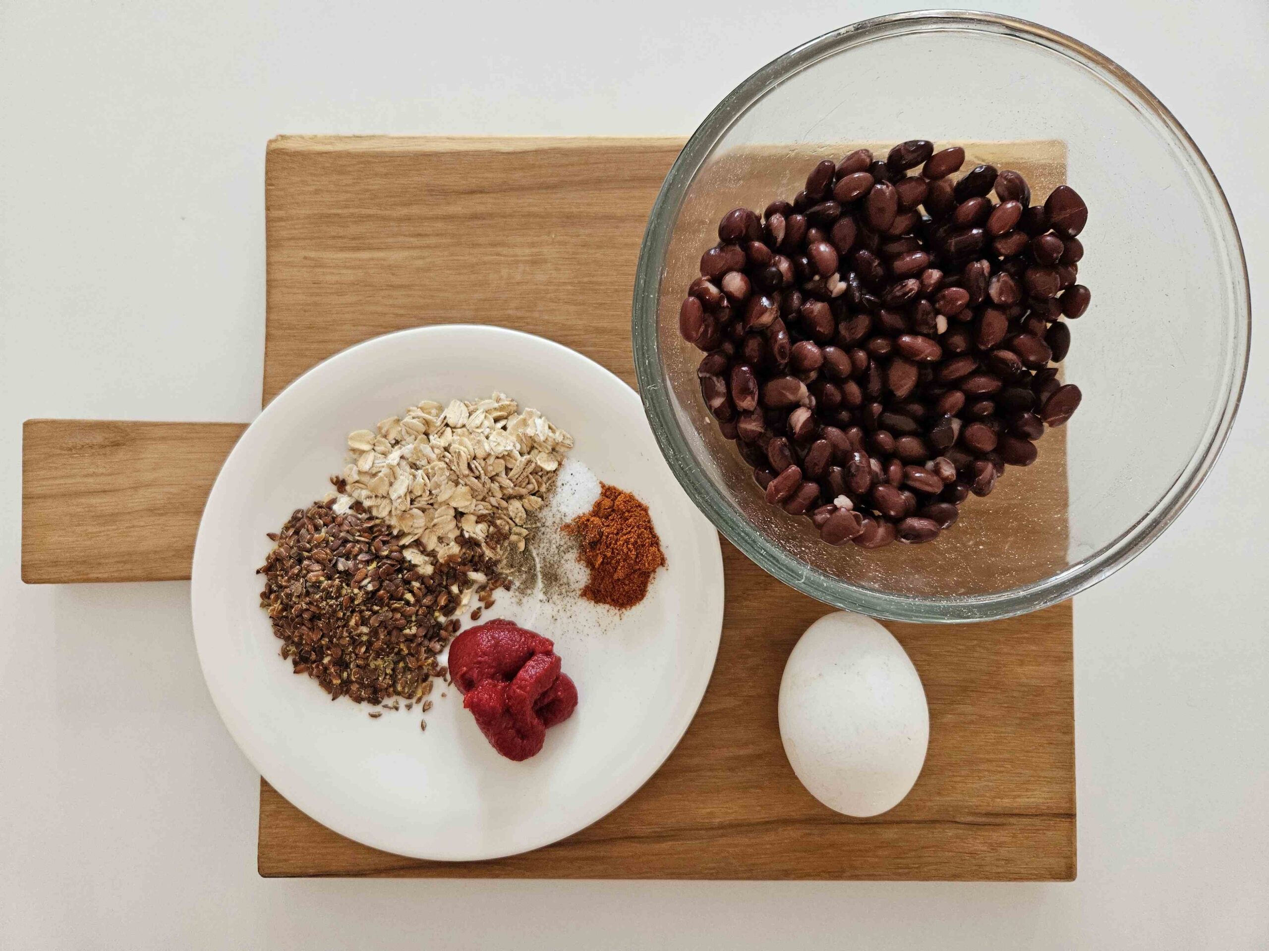 Zutaten für die Bohnen-Frikadellen: schwarze Bohnen, Haferflocken, Leinsamen, Tomatenmark, Paprikapulver, Salz, Pfeffer, ein Ei