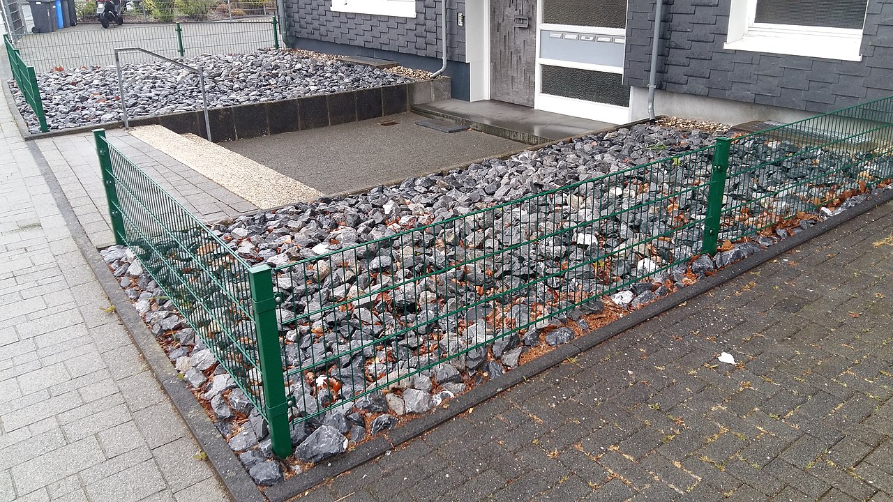 Eingangsbereich eines Hauses mit Schottergarten und ohne Grün.