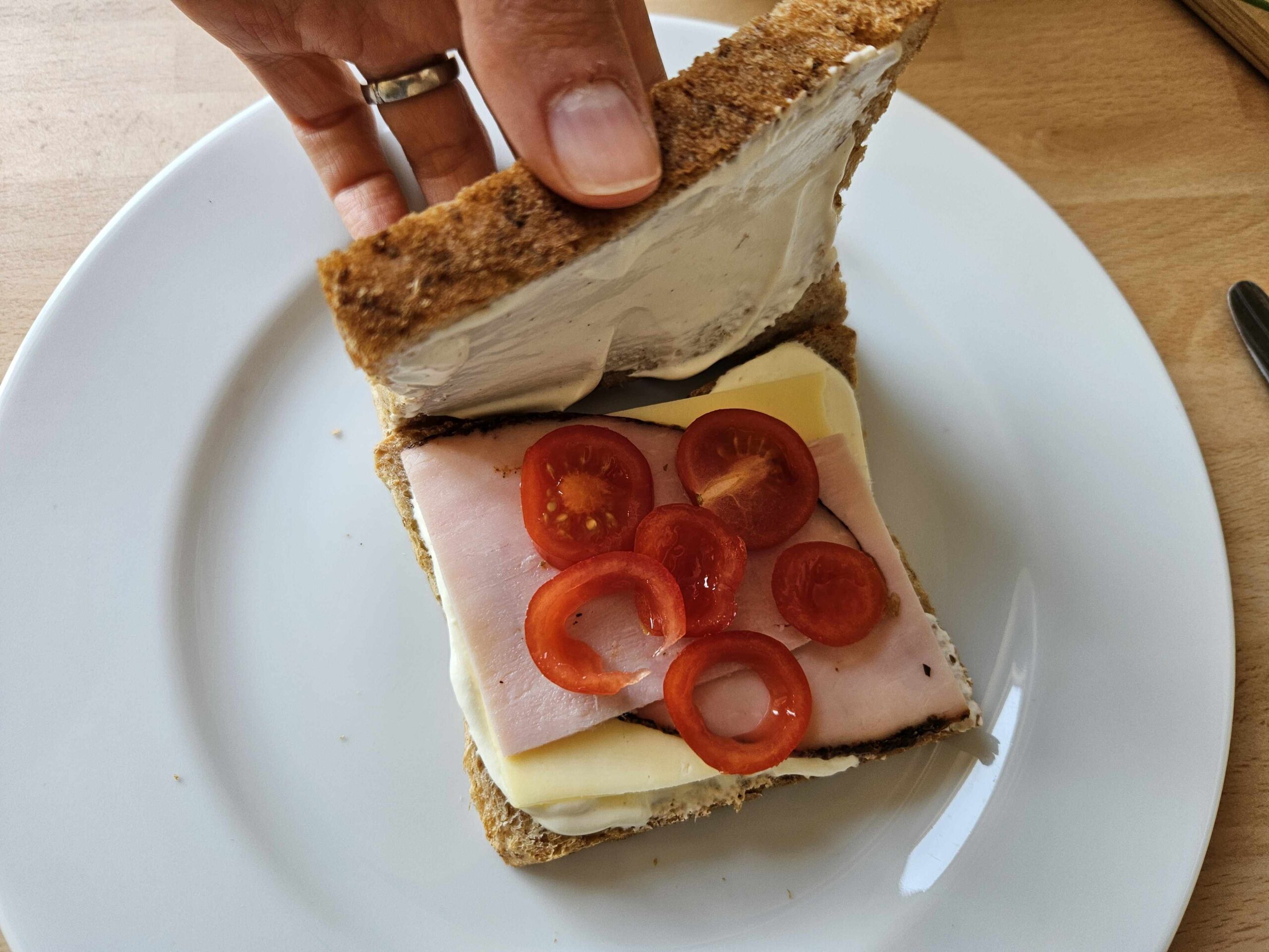 Die Toastscheibe wird mit Creme bestrichen und belegt